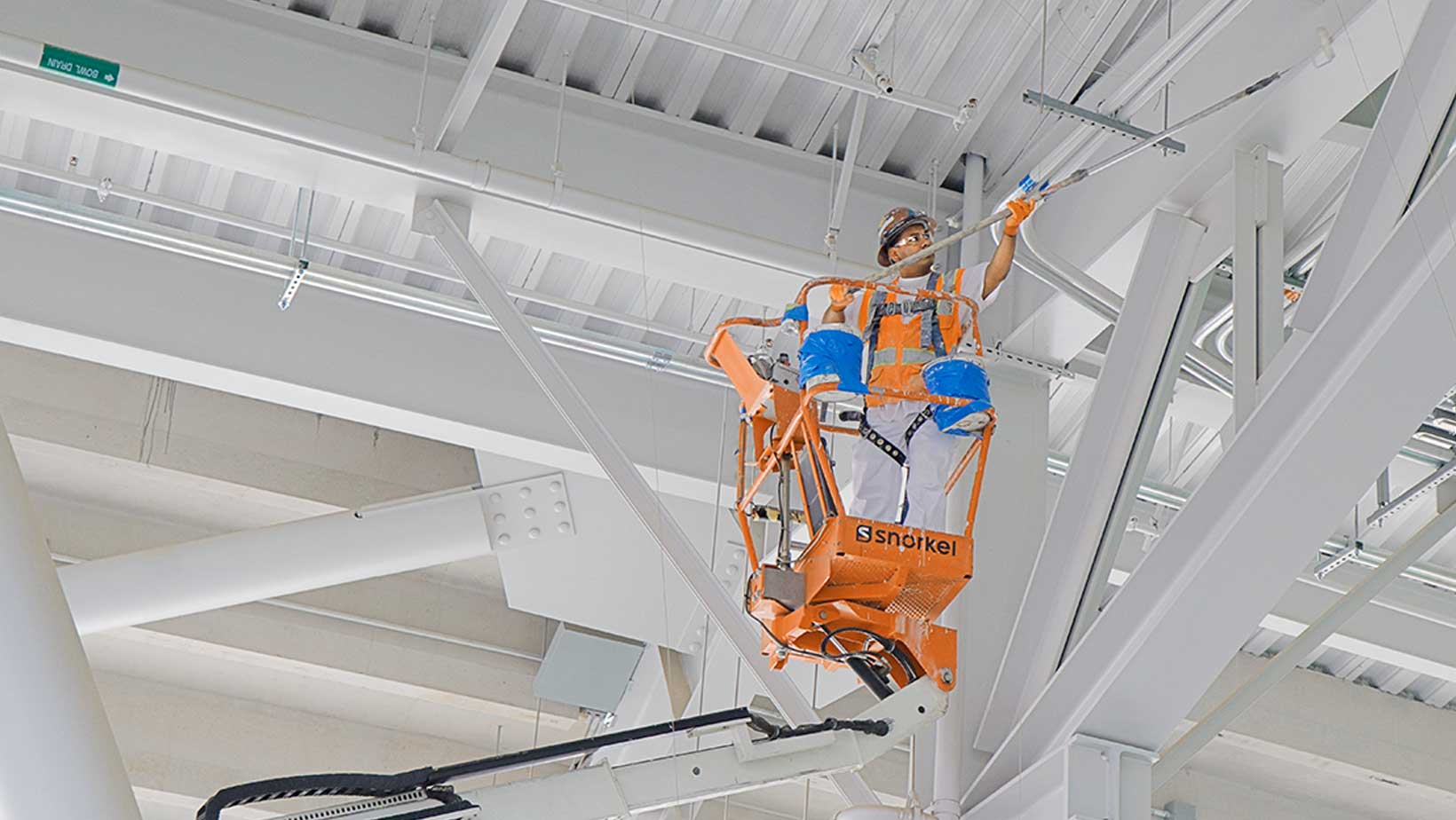 worker-on-lift-painting-cross-beams